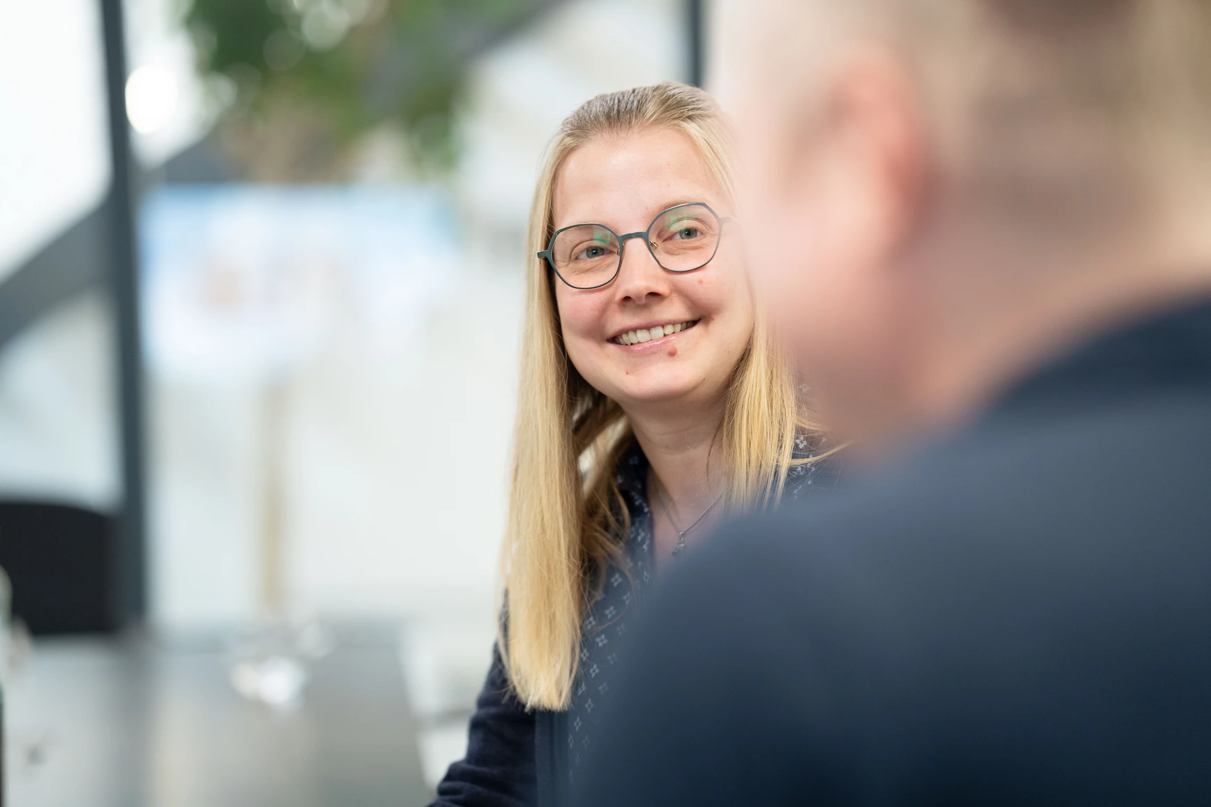 Frau mit Brille lächelt.