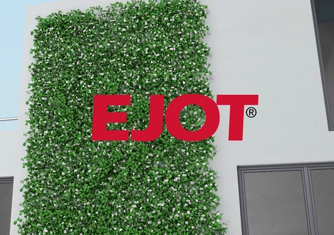 Grüne Wand mit EJOT-Logo am Gebäude.