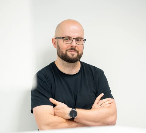 Glatzköpfiger Mann mit Brille und Bart.